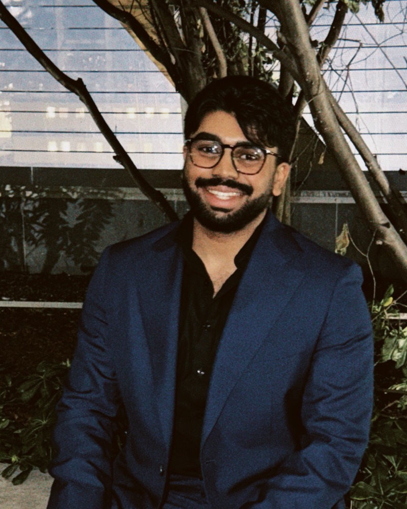 Rohith Devanathan, founder of Veeran Advisory, seated outdoors in a blue suit.
